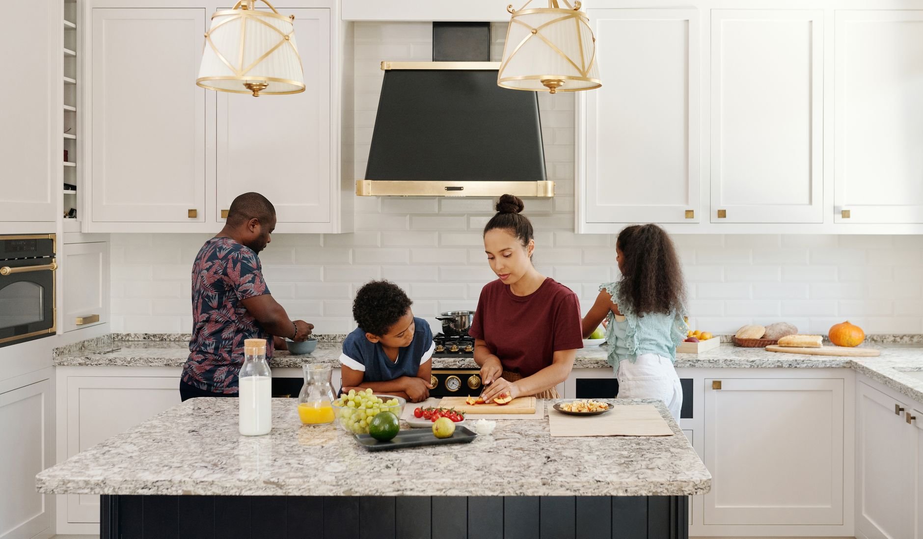 Family enjoying a cooking session together in a bright modern kitchen setting.